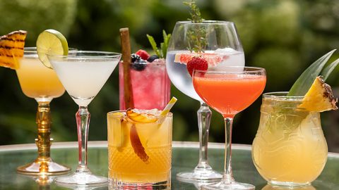 verschillende cocktailglazen zijn belangrijke cocktailbenodigdheden. Ook zie je hier cocktail accesoires zoals rietjes.